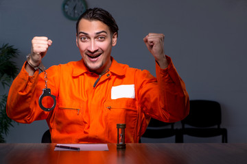 Young convict man sitting in dark room