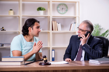 Young man visiting experienced male lawyer