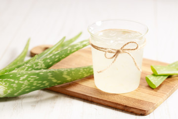 aloe vera juice in a glass on wooden paddle board