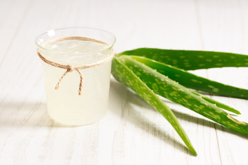 aloe vera juice in a glass on wooden paddle board