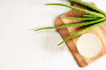 aloe vera juice in a glass on wooden paddle board