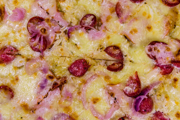 Background of the pizza with sausages, ham and parmesan cheese