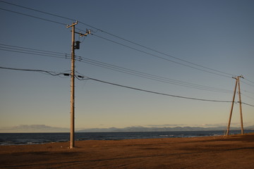 Fototapeta na wymiar 夕暮れの海岸線の電柱