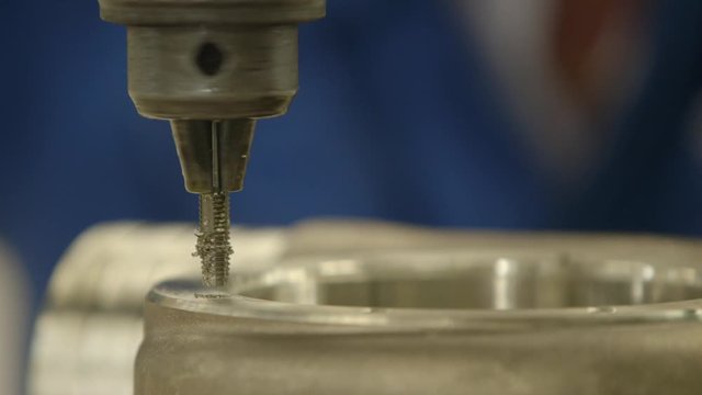 Close up of steel drilling machine carwing out holes