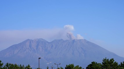 A view from above on an active volcano releasing puffs of smoke into the air. flight to the crater of the volcano at a bird's eye view. volcano eruption
