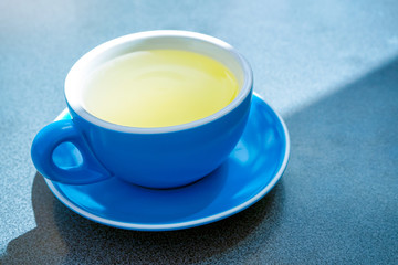 Healthy drink, a blue cup  of hot lemonade, ginger and honey.The beverage often used to help relieve cold and flu symptoms.