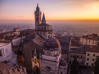 Bergamo, Italy. The old town. Amazing aerial view of the Basilica of Santa Maria Maggiore and the chapel Colleoni. Landscape of the city center and Its landmarks during a wonderful sunset - obrazy, fototapety, plakaty