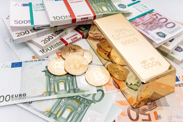 Bitcoin BTC Gold coins with bills of euro banknotes and gold bullion. Bitcoin and gold lie on Euro banknotes