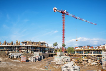 Construction of a building with a construction crane against the blue sky