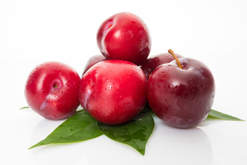 plums with plum leaves isolated on a white background