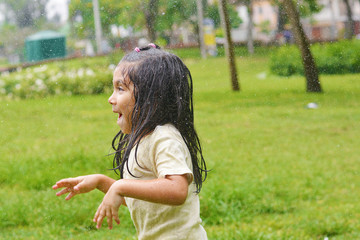 Excited latin kid because of the rain.