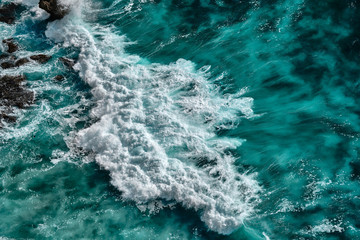 Aerial view to seething waves with foam. Waves of the sea meet each other during high tide and low tide.