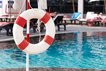 Red lifebuoy ring near the swimming pool. Rescue concept.