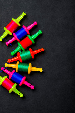 Spool with colourful thread or manjha or manja on dark background. Indian festival makar sankranti concept 
