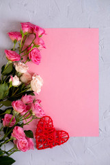 Valentine's Day background. Roses on pastel pink background  and a red heart.