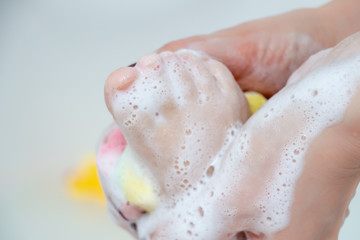 Care and cleanliness concept. Daily washing of the child. A small leg in the hands of the mother, close-up. Bathing for children