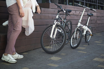 View on man legs standing beside two bicycles on a sidewalk