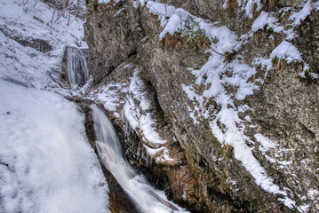 Winter landscape in the valley of mountains with a beautiful stream and snow around, Slovakia Mala Fatra, Janosik Holes