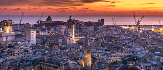 Genoa, Genova, Italy: Amazing sunset panoramic aerial view of Genoa old town historic centre (San Lorenzo Cathedral, duomo, Palazzo Ducale, Torre Grimaldina), sea and port at dusk, by night. Panorama