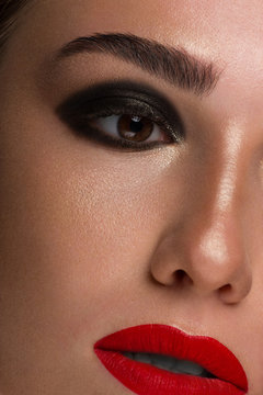 Close-up shot of woman lips with red lipstick. Beautiful perfect lips. Sexy mouth close up and extram eyelashes. Beautiful wide smile of young fresh woman with full red lips and smoky eyes