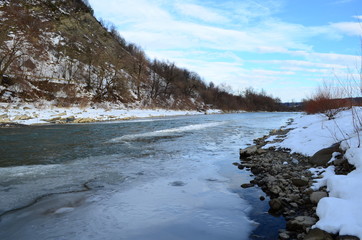 winter landscape in the forest with snow and blue sky and river