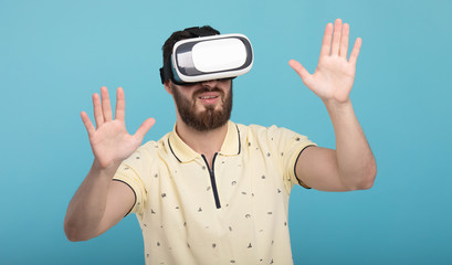 Young man using VR glasses headset trying to touch objects in virtual reality. Isolated white background.