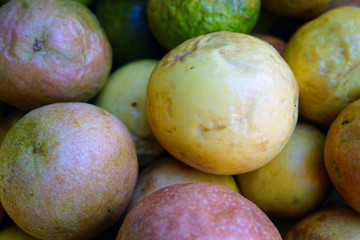 Crate of colorful ripe passion fruits at a food market