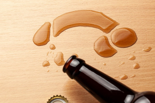 Impotence from alcohol. Beer bottle and beer spilled in the shape of penis