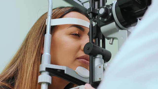 Eyes measured with refractometer at optician or ophthalmologist. Ophthalmologist measuring intraocular pressure of young woman in clinicogist measuring intraocular pressure of young woman in clinic