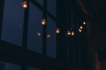 garland of light bulbs on the background of a large window