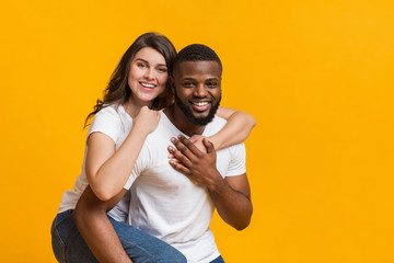 Afro guy giving piggyback ride to his girlfriend