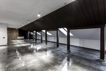 Empty unfurnished loft mansard room interior with wooden columns and wet concrete floor on roof level in black and whote style color