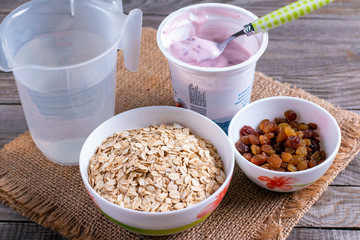 Cooking oatmeal porridge. Ingredients on a wooden table.