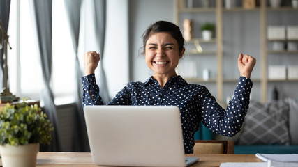 Euphoric young indian girl celebrate online victory triumph with laptop