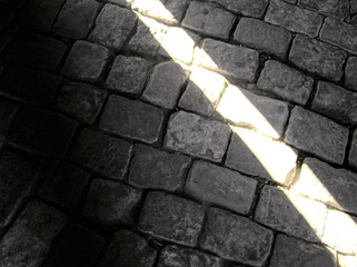 Light and shade. A strip of light on a stone floor. Black and white photo. - 313375739