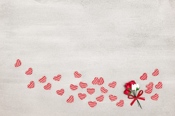 Small textile hearts and flowers on concrete surface with copy space. Romantic background