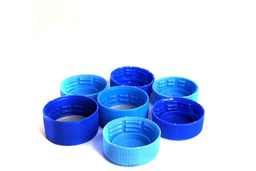 blue plastic bottle caps isolated on white background. Solutions for recycling plastic waste.