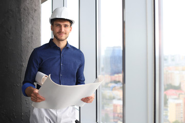 Shot of male architect wearing hardhat and inspecting new building.