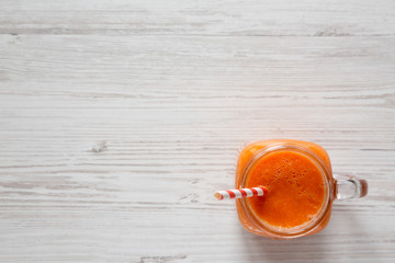 Homemade Mango Carrot Smoothie in a glass jar mug, top view. Flat lay, overhead, from above. Copy space.