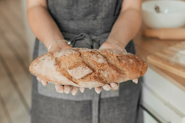 Beautiful housewife in a stylish apron cooks in a cozy kitchen. Close-up