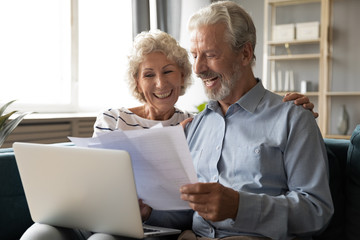 Elderly couple using online banking website check savings feels satisfied