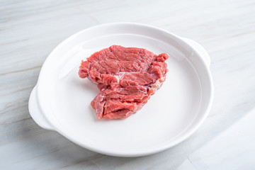 A piece of fresh yellow beef on a kitchen tile countertop plate
