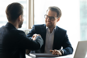 Business partners handshake closing deal at meeting