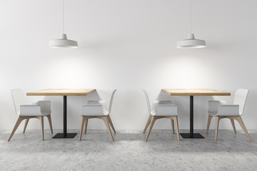 Square dining tables in white cafe interior