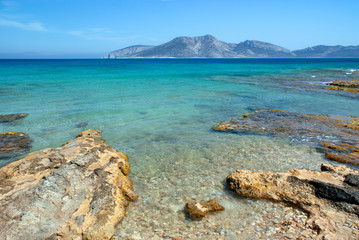 Fototapeta na wymiar Greece, the island of Koufonissi. A view the uninhabited island of Keros. A rocky shoreline with crystal clear blue sea waters. Keros has major archaeological remains.