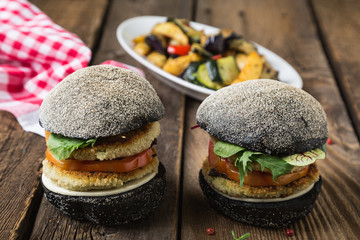 Vegetarian hamburger with a vegetable cutlet on a black bun