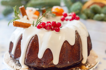 Christmas cake with candied fruit with icing and cinnamon and red currant decorations