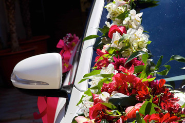 The composition from fresh flowers on the holiday car.