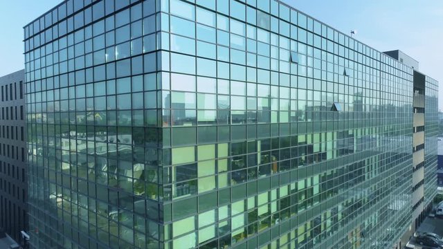 Aerial closeup of the glass facade of an office building. 4K