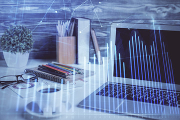 Stock market graph on background with desk and personal computer. Multi exposure. Concept of financial analysis.